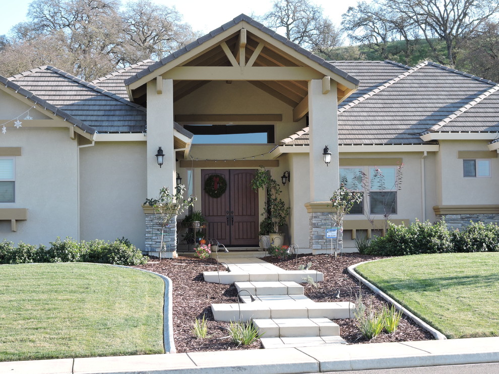 Large elegant gray one-story stucco house exterior photo in Sacramento with a hip roof and a shingle roof