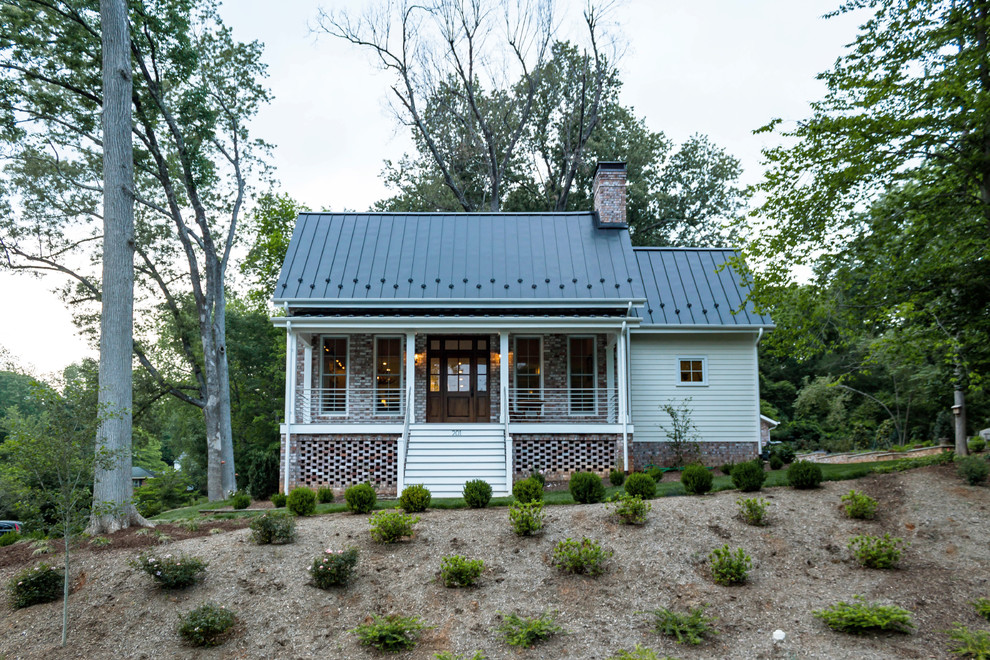 Example of a transitional two-story brick exterior home design in Raleigh with a metal roof