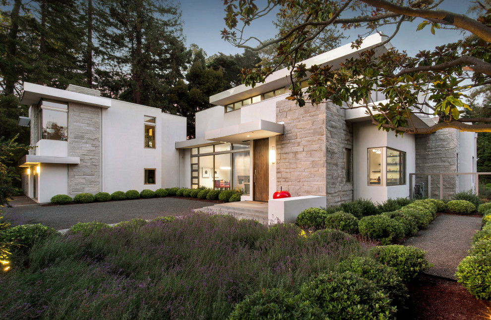 Diseño de fachada de casa multicolor actual grande de dos plantas con revestimientos combinados y tejado plano