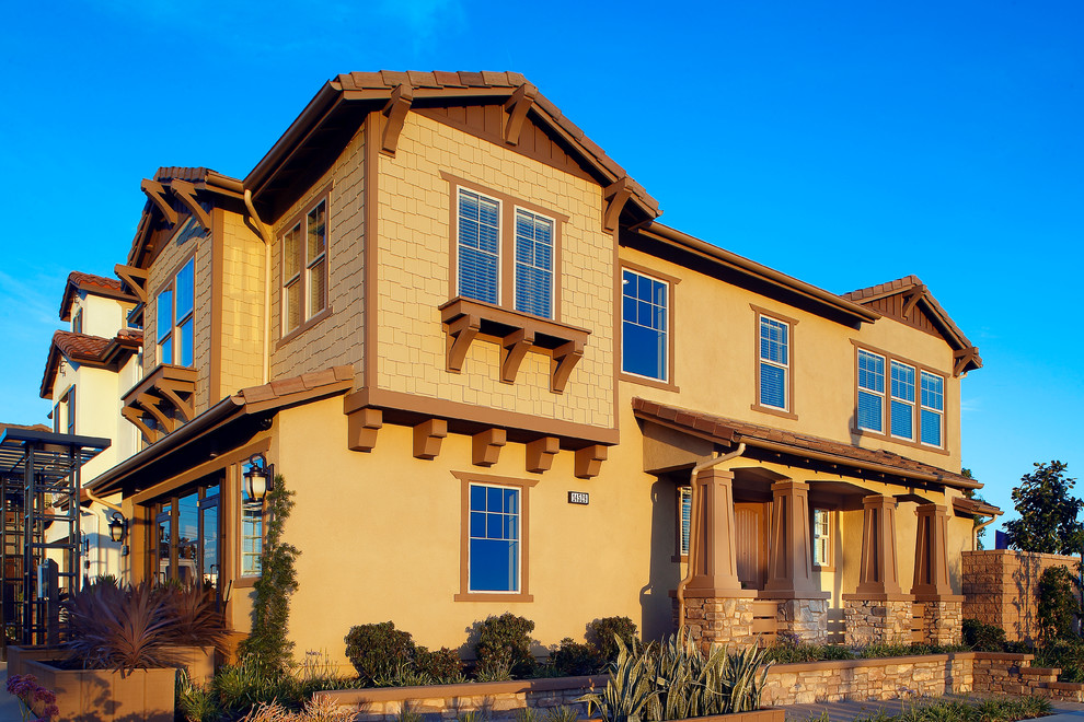 Cette image montre une façade de maison marron en adobe à un étage et de taille moyenne.