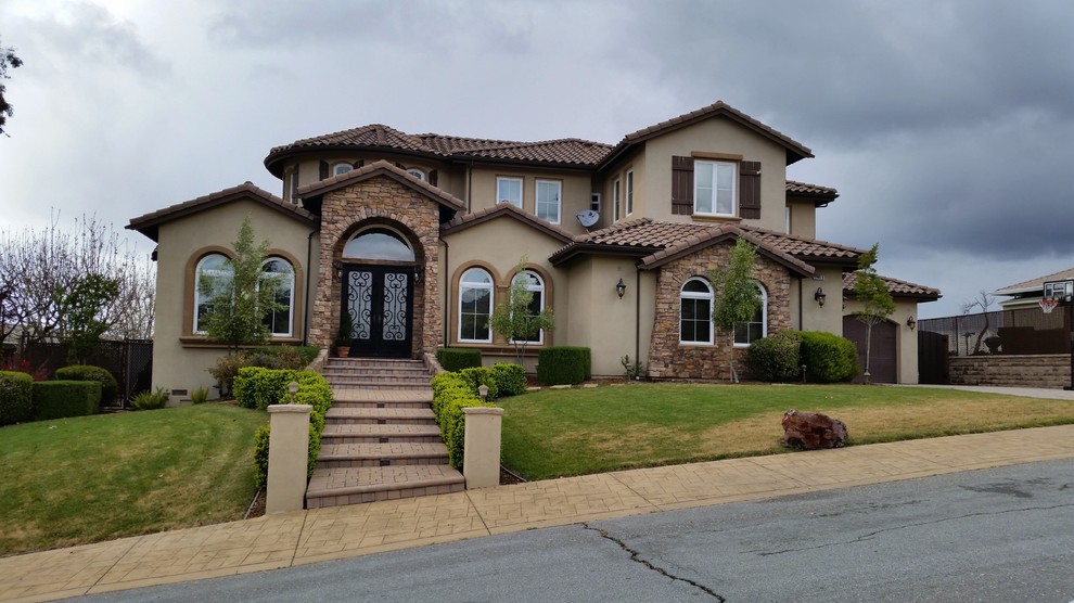 Photo of a medium sized and beige mediterranean two floor detached house in San Francisco with mixed cladding, a hip roof and a tiled roof.