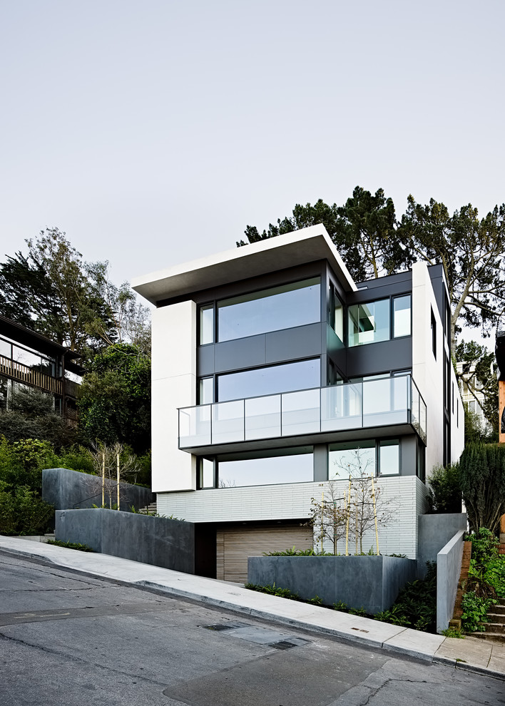 Imagen de fachada de casa multicolor moderna de tres plantas con tejado plano