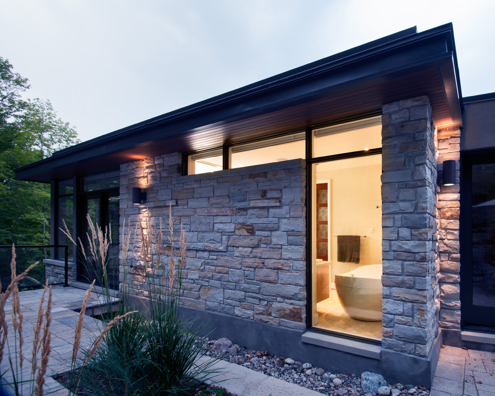 Diseño de fachada de casa actual de tamaño medio con revestimiento de piedra