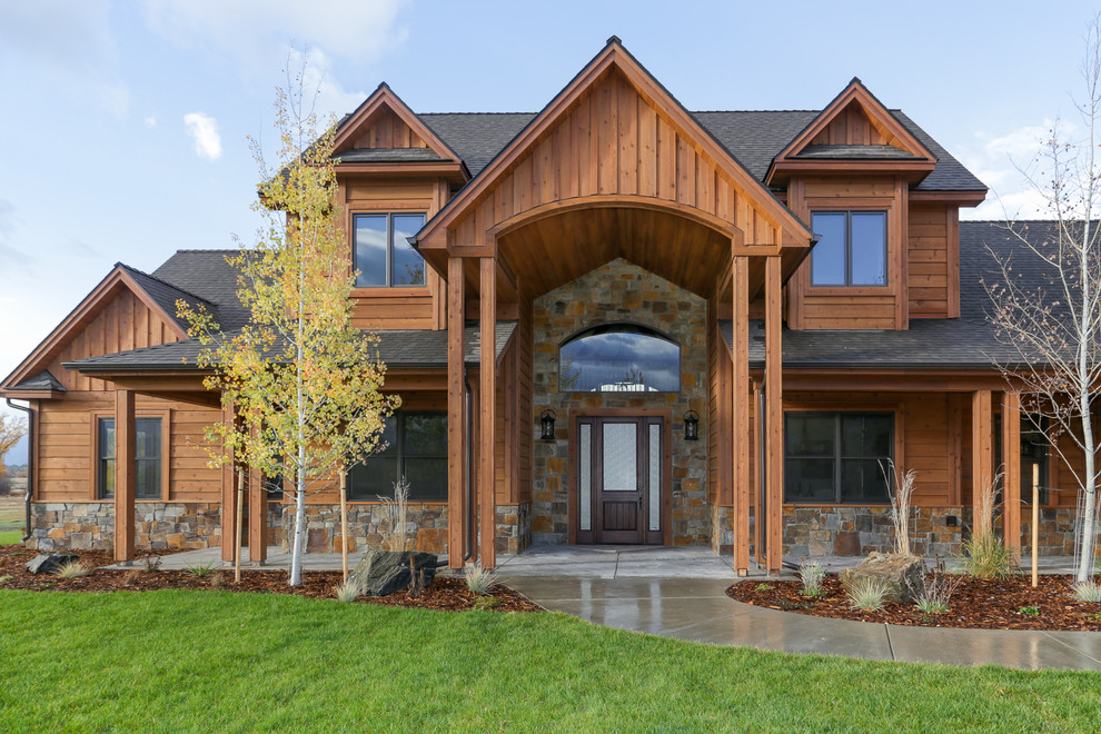 Example of a large mountain style brown two-story wood exterior home design in Other with a shingle roof