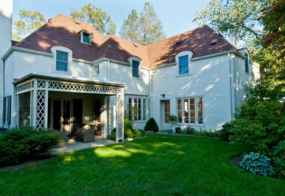 Aménagement d'une grande façade de maison blanche campagne en brique à deux étages et plus avec un toit à quatre pans et un toit en shingle.