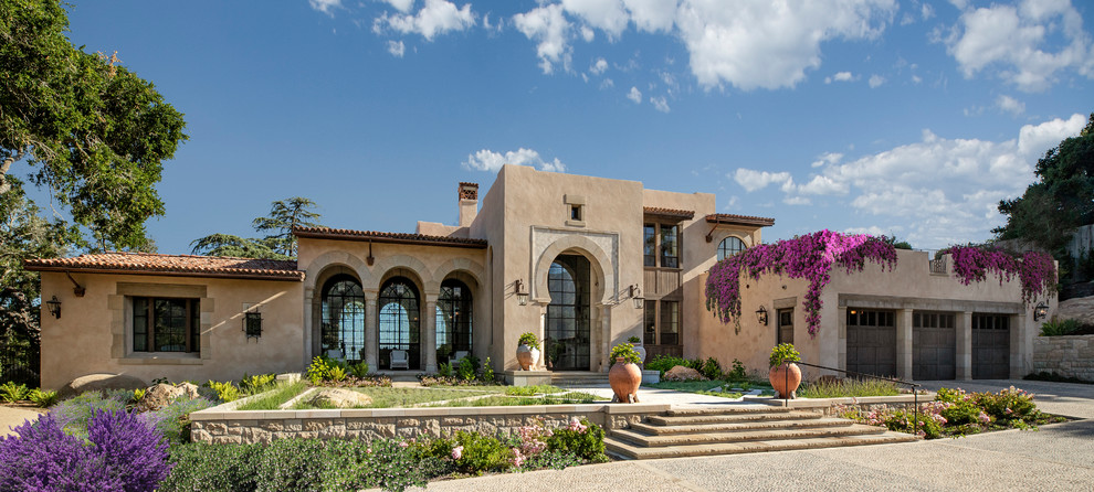 Immagine della villa beige mediterranea a due piani con tetto piano e copertura in tegole