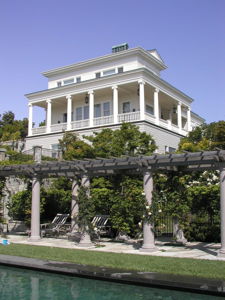 Immagine della facciata di una casa bianca classica a tre piani con rivestimento in legno