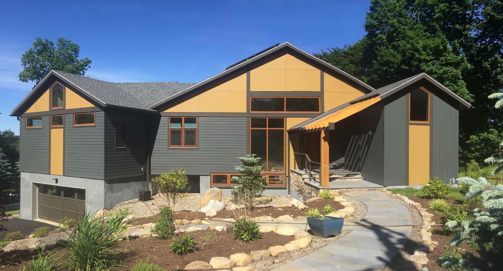 Foto de fachada de casa multicolor actual de tamaño medio de dos plantas con revestimientos combinados, tejado a dos aguas y tejado de teja de madera