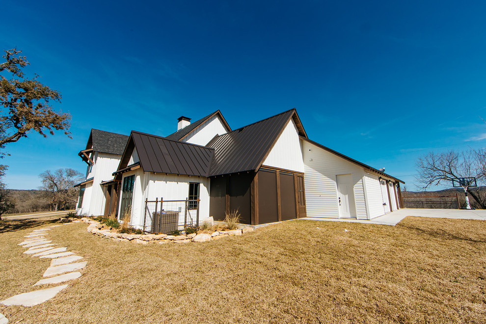 Geräumiges, Dreistöckiges Country Haus mit weißer Fassadenfarbe, Satteldach und Blechdach in Austin