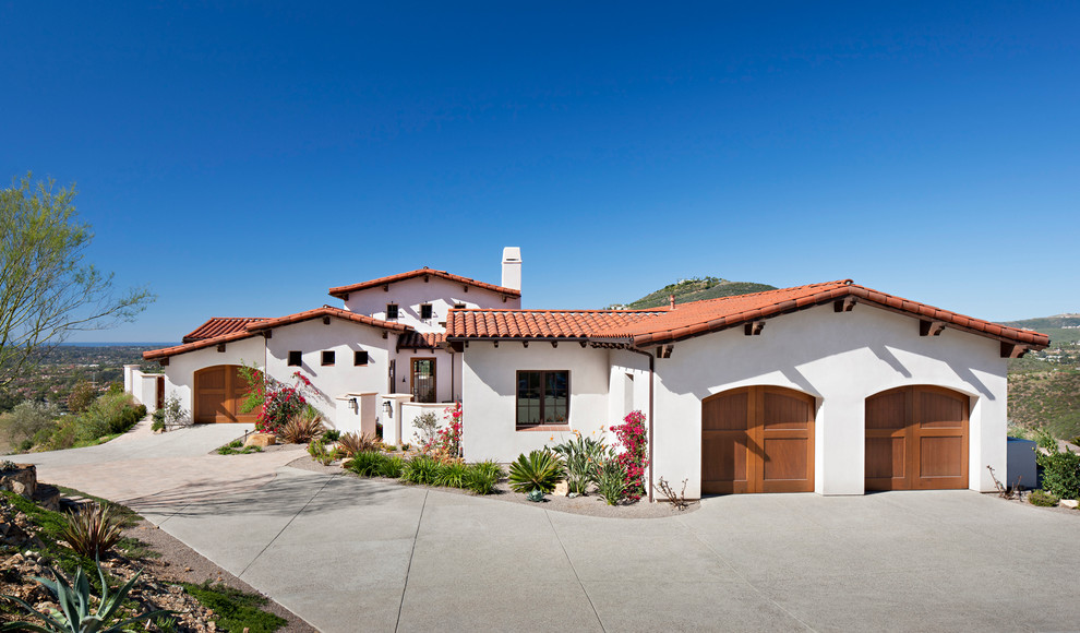 Großes, Zweistöckiges Mediterranes Haus mit Lehmfassade, weißer Fassadenfarbe und Walmdach in San Diego