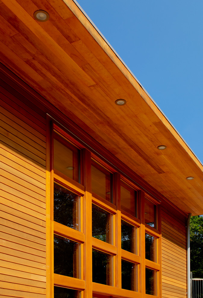 Modelo de fachada de casa multicolor contemporánea grande de dos plantas con revestimientos combinados, tejado a dos aguas y tejado de metal