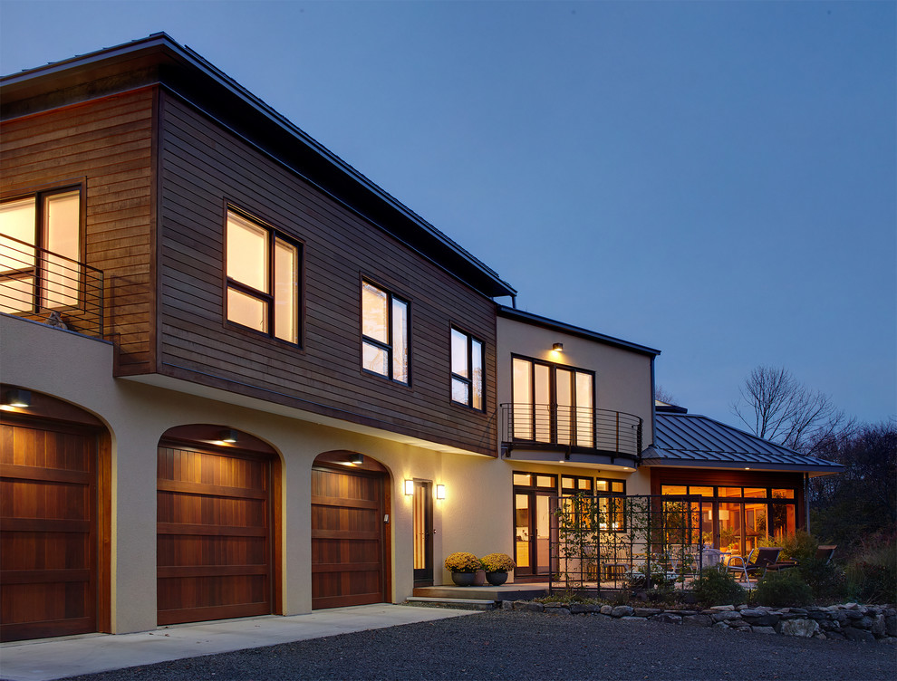 Imagen de fachada de casa beige contemporánea grande de dos plantas con revestimiento de madera, tejado a dos aguas y tejado de metal