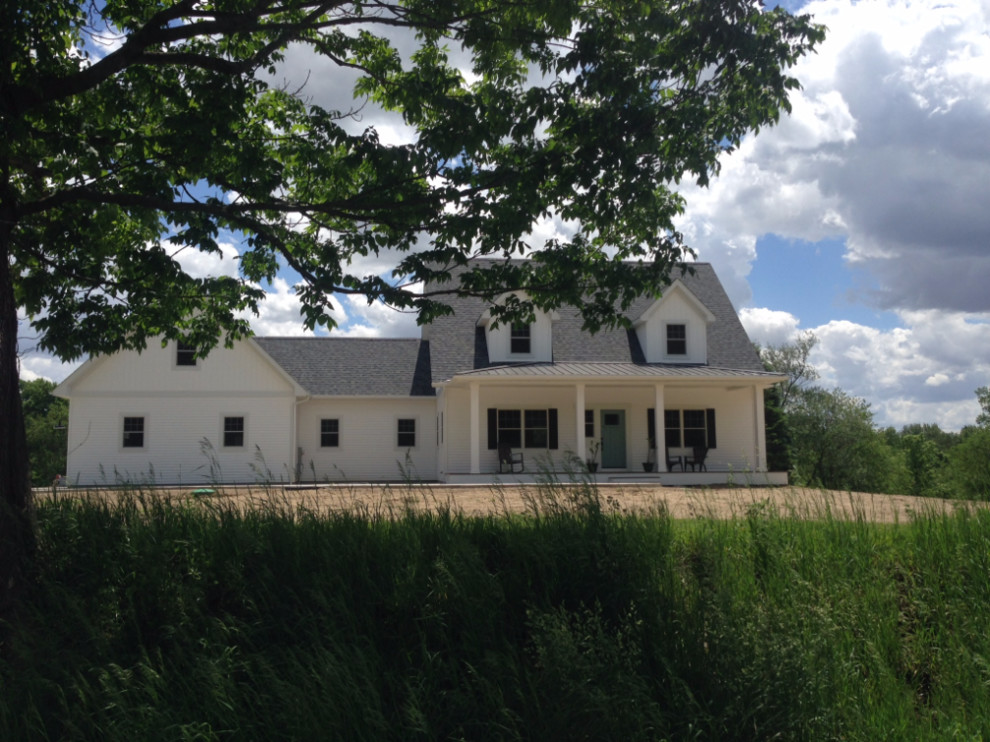 На фото: двухэтажный, деревянный, белый частный загородный дом среднего размера в стиле кантри с двускатной крышей и крышей из гибкой черепицы с