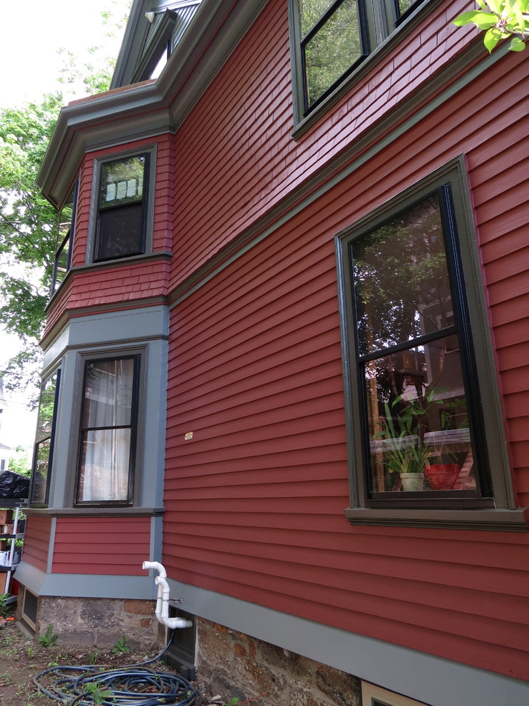 Idée de décoration pour une façade de maison rouge victorienne en bois.