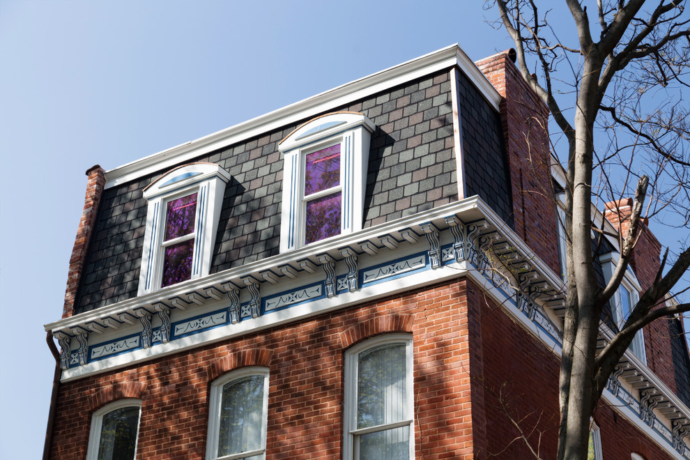 Immagine della facciata di una casa grande rossa vittoriana a tre piani con rivestimento in mattoni e tetto piano