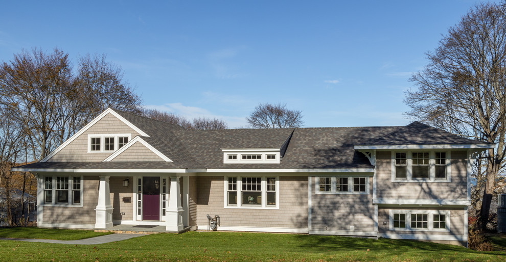 Imagen de fachada de casa beige de estilo americano de tamaño medio a niveles con revestimiento de madera y tejado a dos aguas
