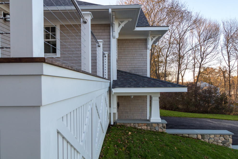 Esempio della villa beige american style a piani sfalsati di medie dimensioni con rivestimento in legno, tetto a capanna e copertura a scandole