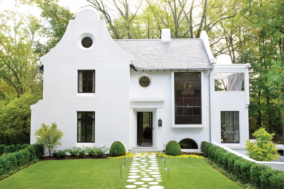 Modelo de fachada de casa blanca clásica renovada de tamaño medio de dos plantas con tejado de teja de madera, revestimiento de adobe y tejado a dos aguas