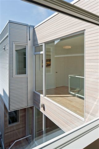 Réalisation d'une façade de maison blanche minimaliste de taille moyenne et à un étage avec un revêtement mixte et un toit plat.