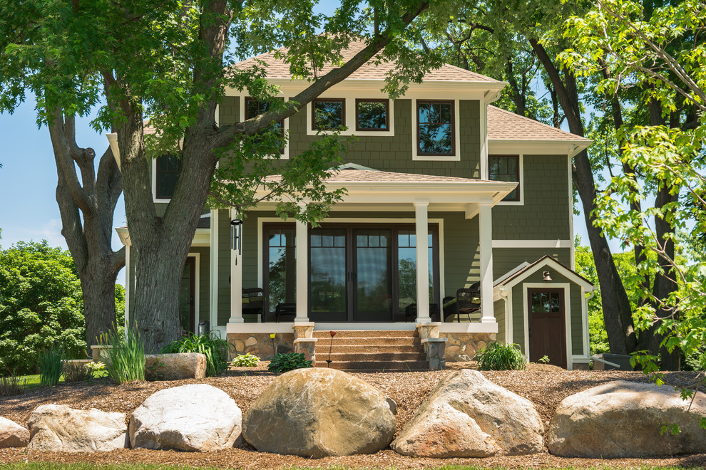 Example of a farmhouse green stone exterior home design in Detroit