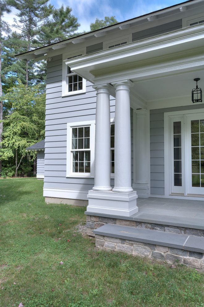 Ejemplo de fachada gris clásica de dos plantas con revestimiento de madera y tejado a dos aguas