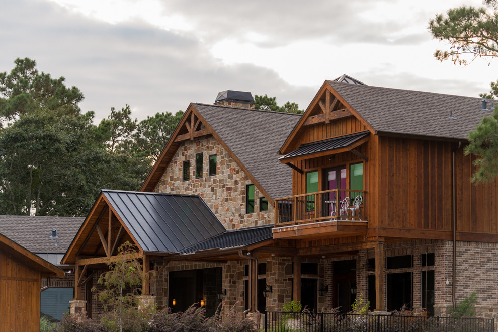 Inspiration for a large rustic beige two-story stone exterior home remodel in Houston with a shingle roof