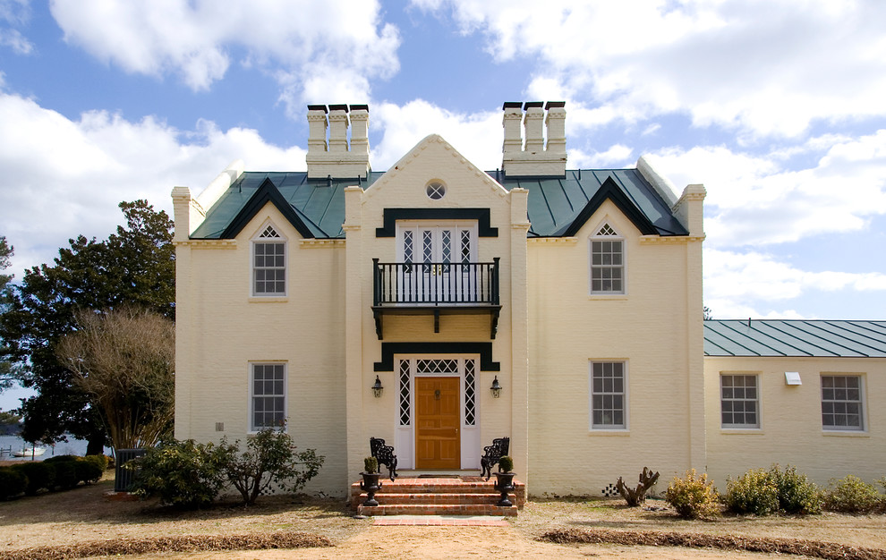Idee per la facciata di una casa grande beige classica a due piani con rivestimento in mattoni