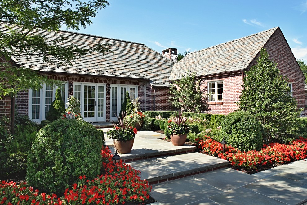 Example of a large arts and crafts brown one-story brick exterior home design in New York with a shingle roof
