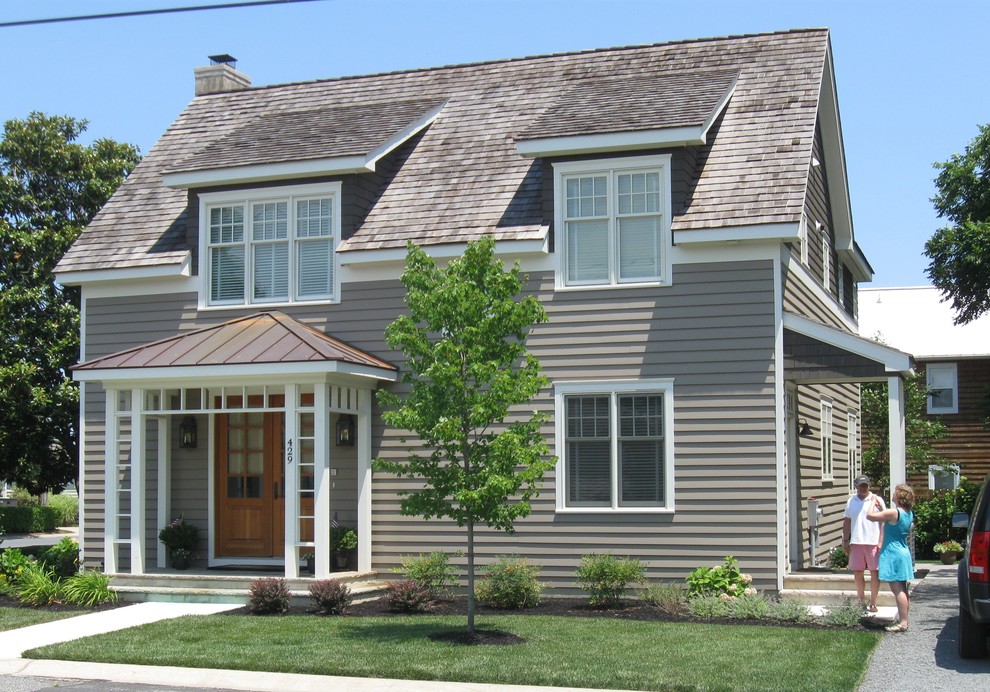 Cette photo montre une façade de maison grise chic en bois de taille moyenne et à un étage.