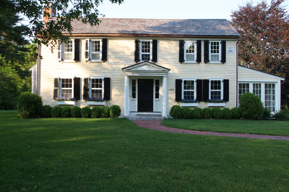 Example of a large country yellow two-story wood exterior home design in Boston with a gambrel roof