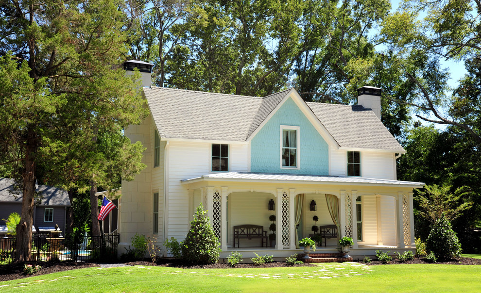 Ejemplo de fachada blanca de estilo de casa de campo de dos plantas con revestimiento de madera y tejado a dos aguas