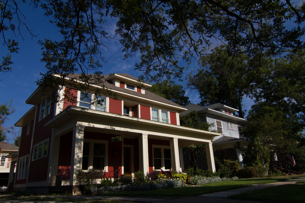 Esempio della facciata di una casa grande rossa american style a due piani con rivestimento in legno