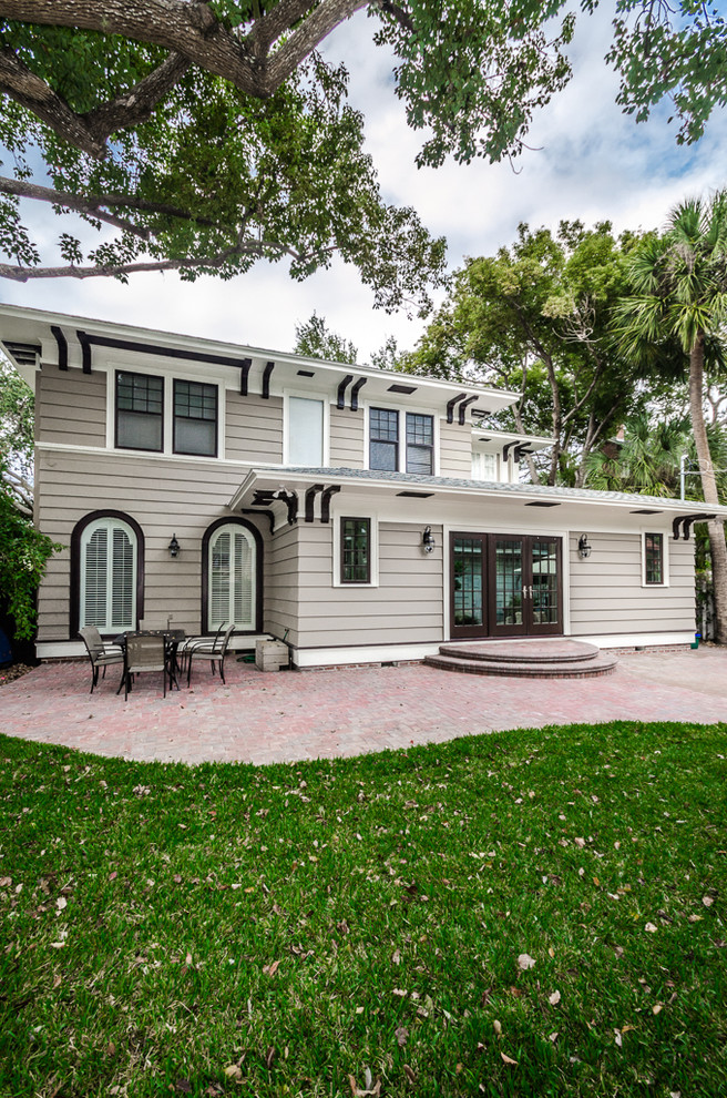 Photo of a beige classic two floor house exterior in Tampa with wood cladding and a hip roof.