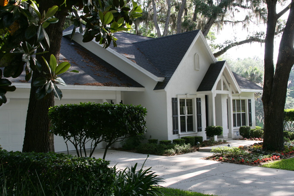 Small elegant white one-story stucco gable roof photo in Orlando