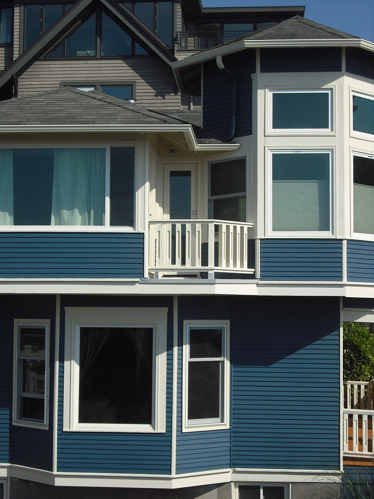 This is an example of a large and blue traditional two floor house exterior in Seattle with wood cladding.