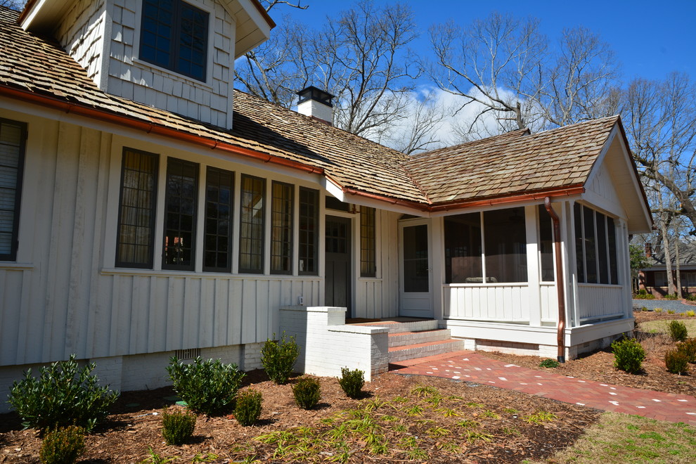 Imagen de fachada blanca de estilo de casa de campo grande de dos plantas con revestimiento de madera, tejado a dos aguas y tejado de teja de madera