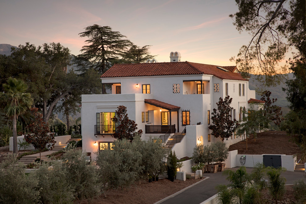 Inspiration for a large and white mediterranean render detached house in Santa Barbara with a hip roof and a tiled roof.