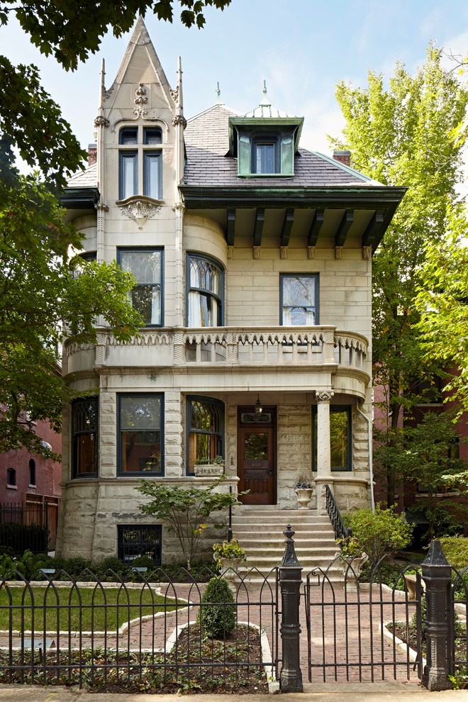 Beige victorian house exterior in Chicago with three floors and a hip roof.