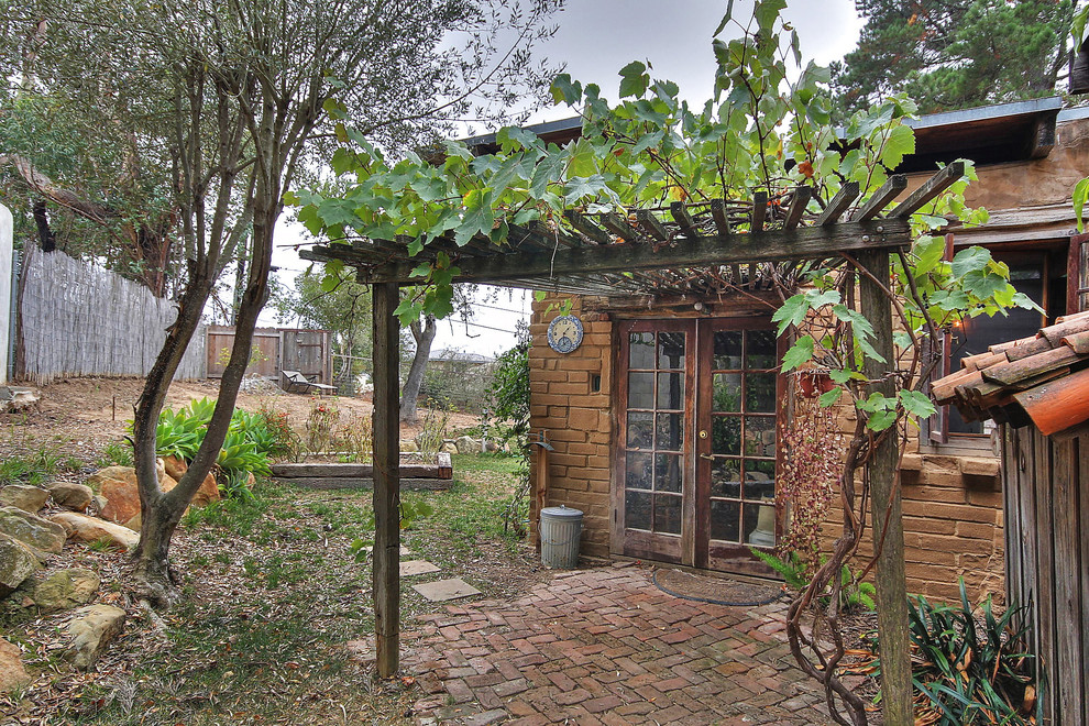 На фото: маленький, одноэтажный, кирпичный дом в стиле рустика для на участке и в саду с