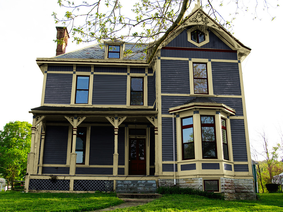 Cette photo montre une façade de maison bleue chic en bois.