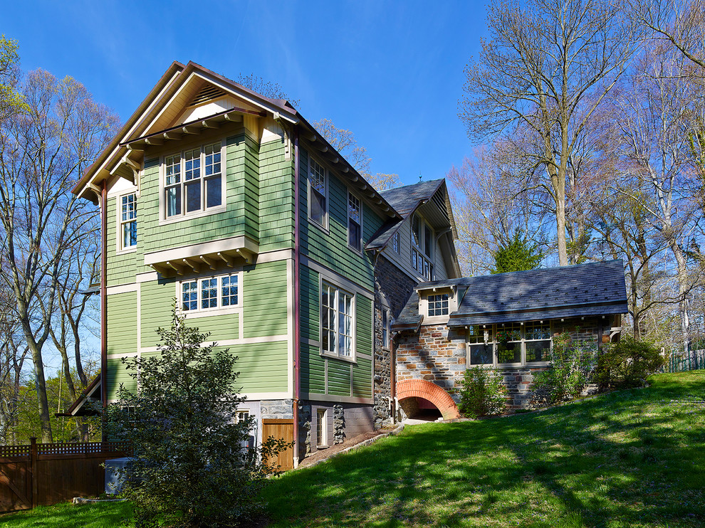Modelo de fachada verde de estilo de casa de campo grande de tres plantas con revestimientos combinados y tejado a dos aguas