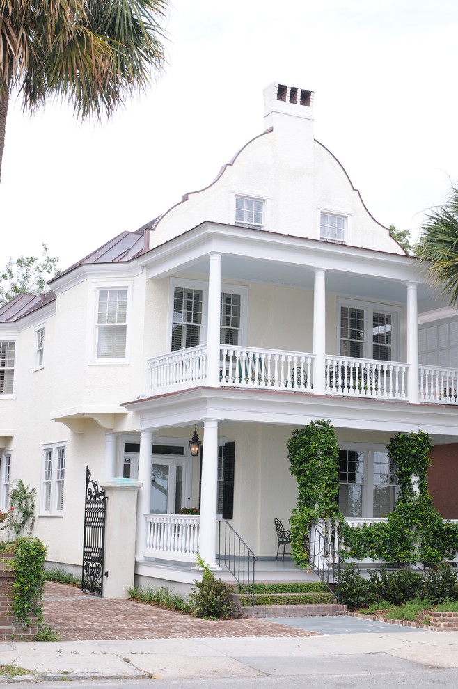 Mittelgroßes, Zweistöckiges Klassisches Haus mit Putzfassade, gelber Fassadenfarbe und Satteldach in Charleston