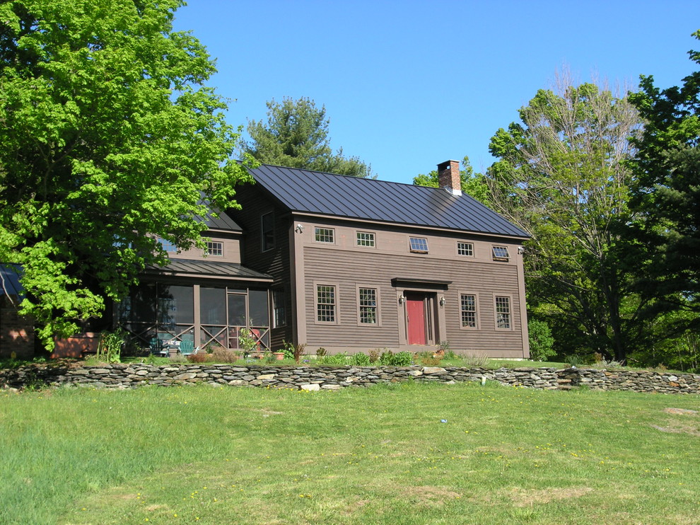 Foto della facciata di una casa country a due piani con rivestimento in legno