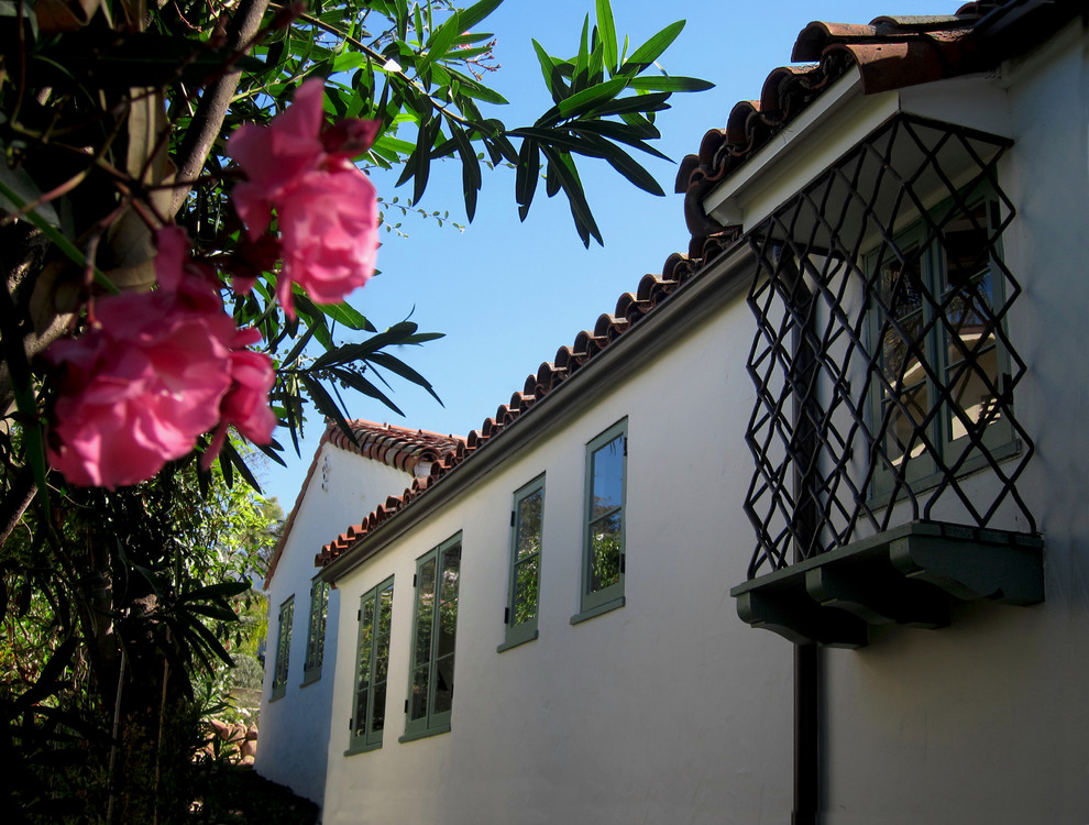 Design ideas for a medium sized and white mediterranean bungalow render detached house in Santa Barbara with a half-hip roof and a tiled roof.