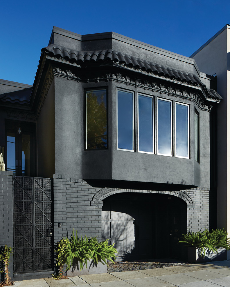 Diseño de fachada negra minimalista grande de tres plantas con tejado plano y revestimiento de estuco
