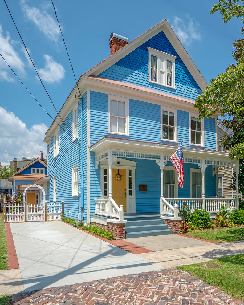 Ejemplo de fachada de casa azul clásica de dos plantas con tejado a dos aguas y tejado de teja de madera