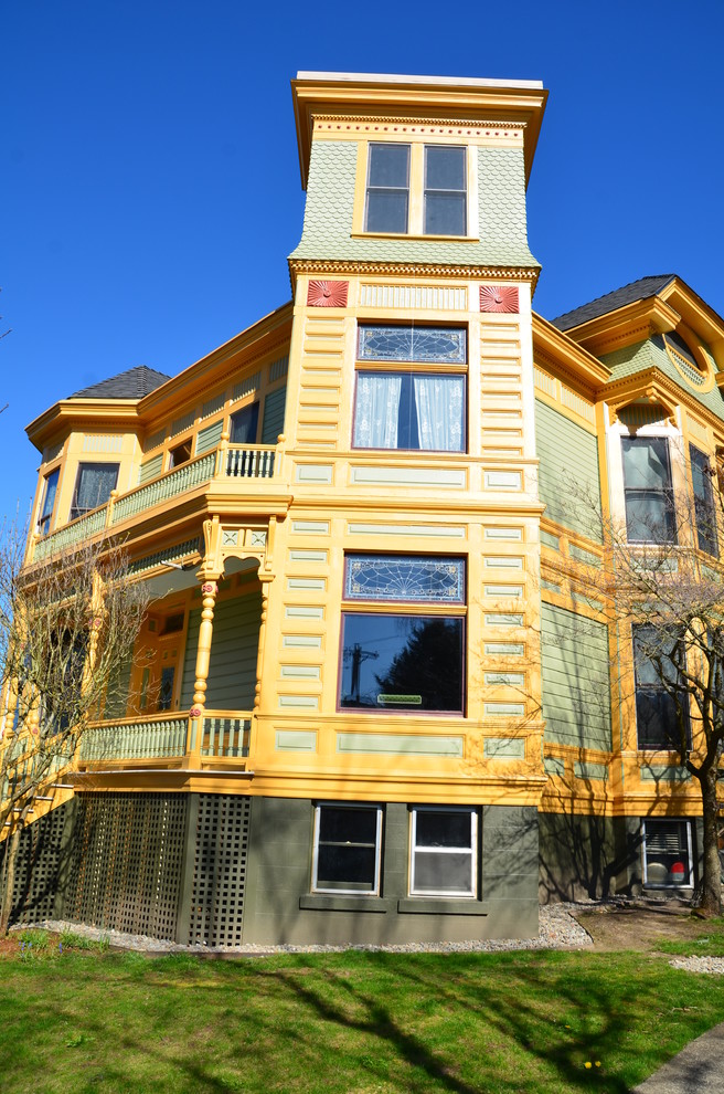 Réalisation d'une façade de maison verte victorienne en bois à deux étages et plus.
