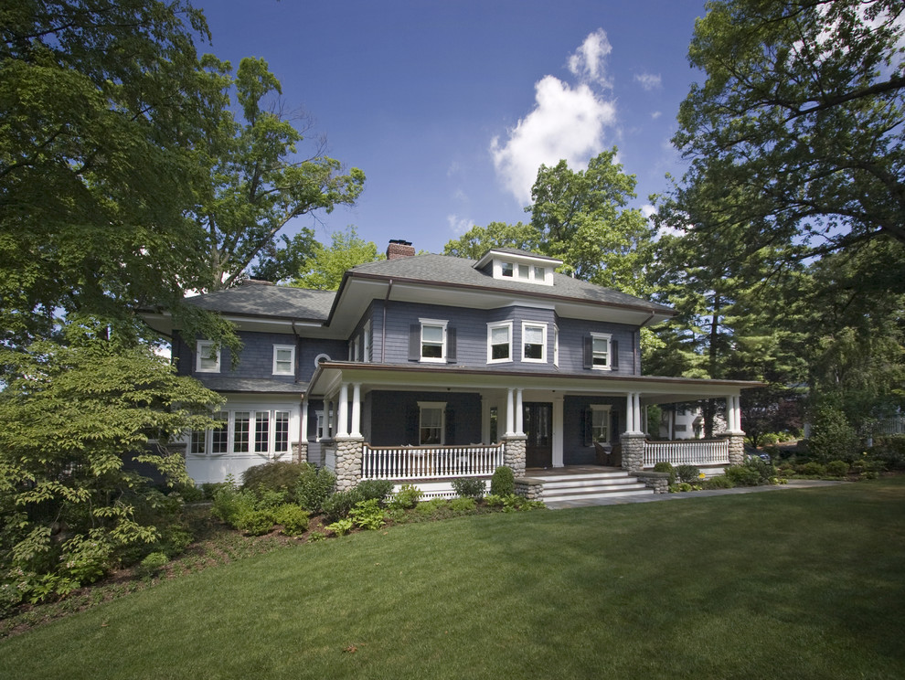 Idée de décoration pour une grande façade de maison bleue tradition en bois à deux étages et plus avec un toit à quatre pans.