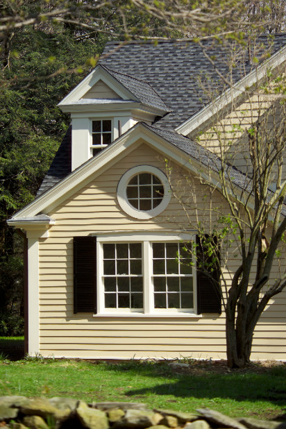 Exemple d'une grande façade de maison jaune chic en bois à un étage avec un toit à deux pans.