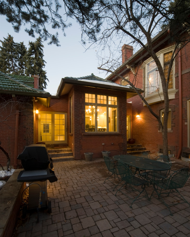 Mid-sized traditional brown one-story brick house exterior idea in Denver with a hip roof and a tile roof